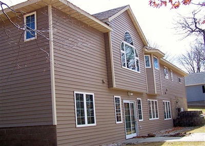 A large beige multi-story residential building with multiple windows, including prominent arched windows on the upper floors.
